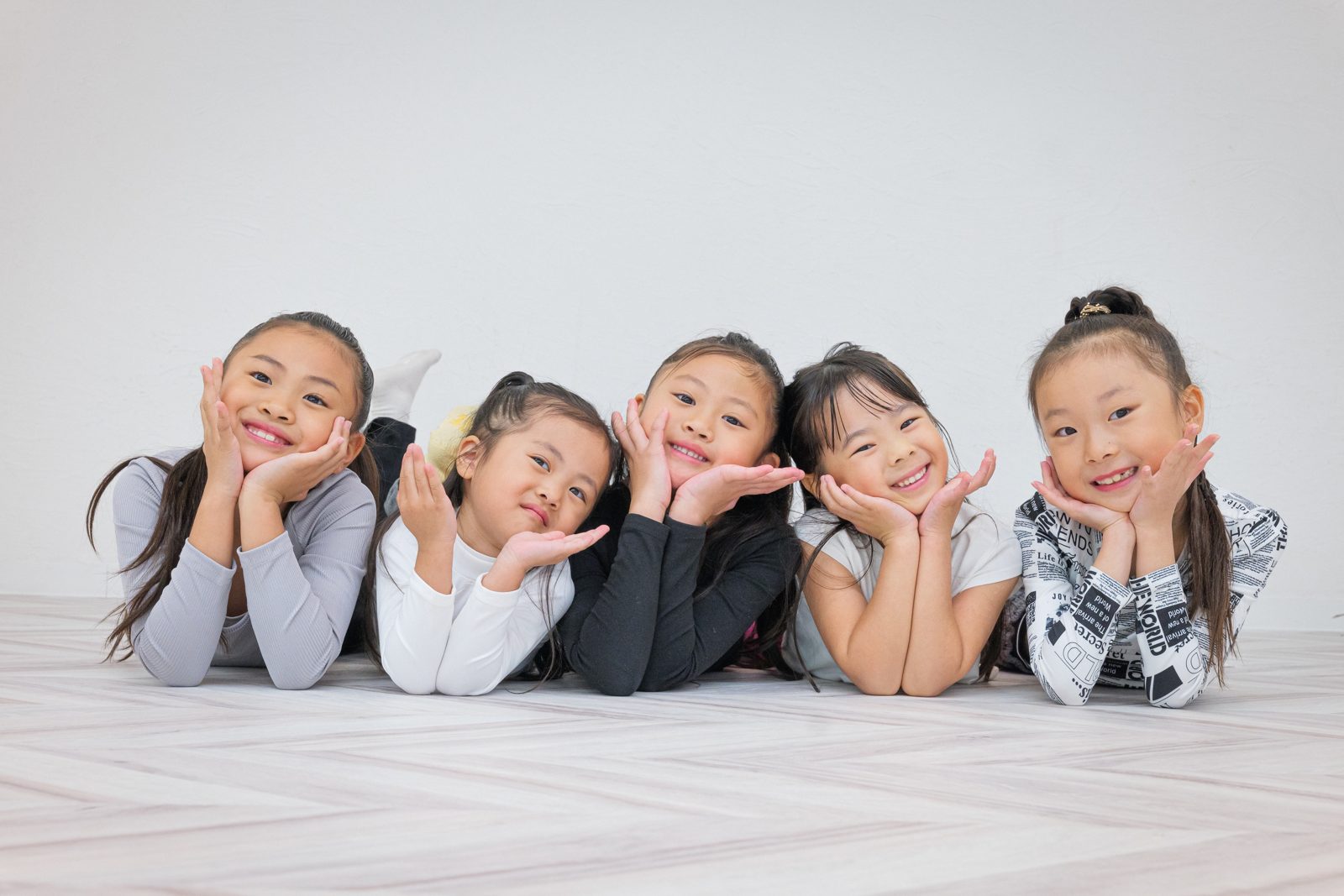 寝そべって頬に手を添える子どもたち