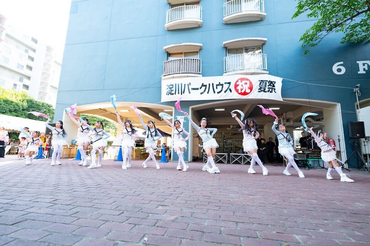屋外ステージで隊形をそろえて踊る様子
