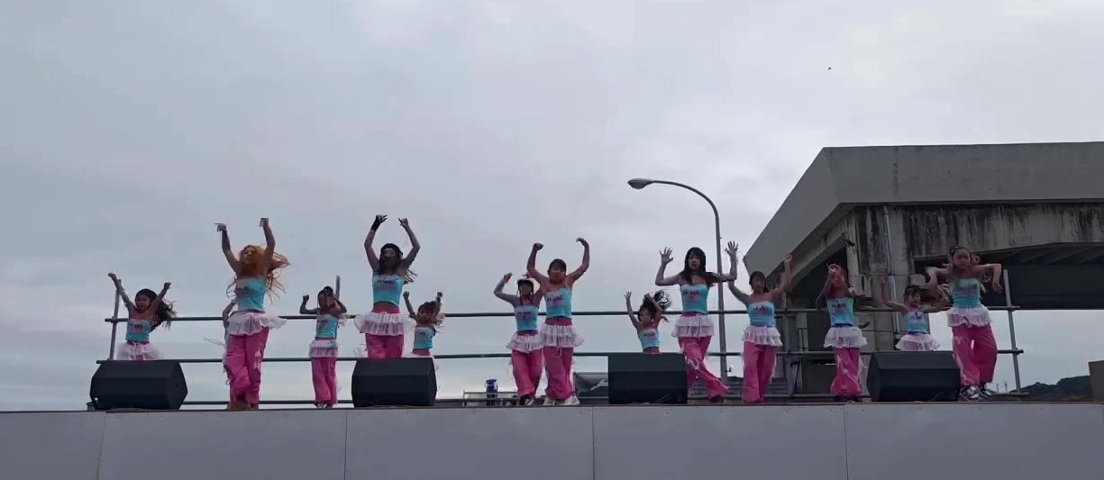 ピンクのパンツの衣装でステージに並んで踊るクラス
