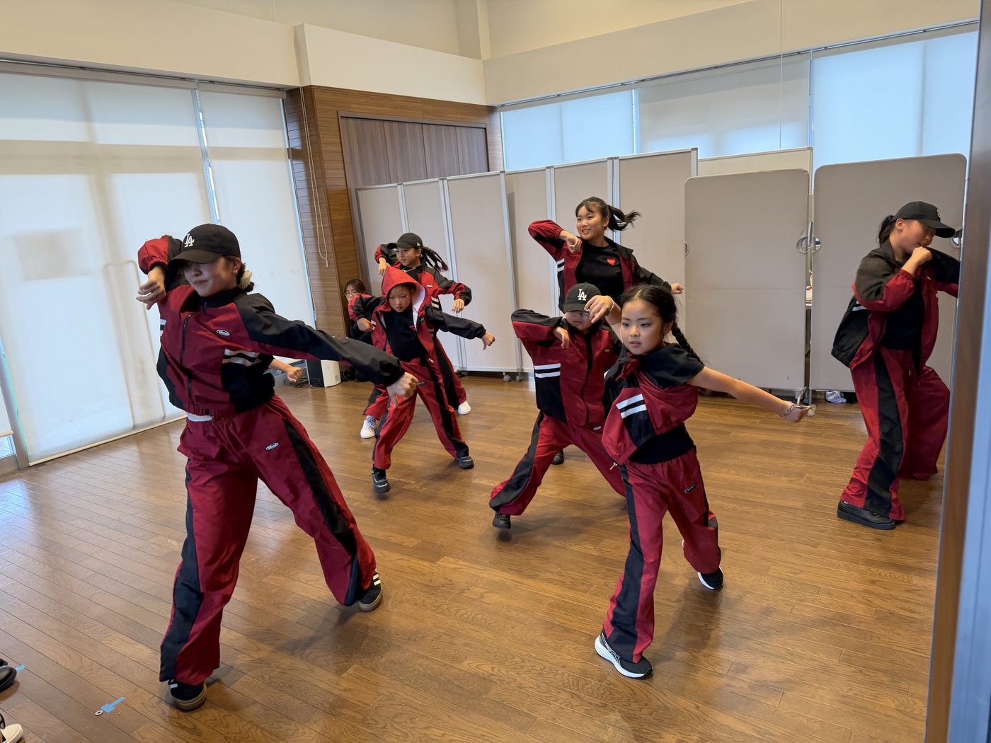 第1部の屋内ステージで赤いジャージの衣装で踊る生徒たち